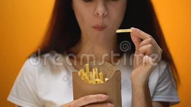 女孩吃炸薯条，享受快餐，高热量膳食，肥胖风险